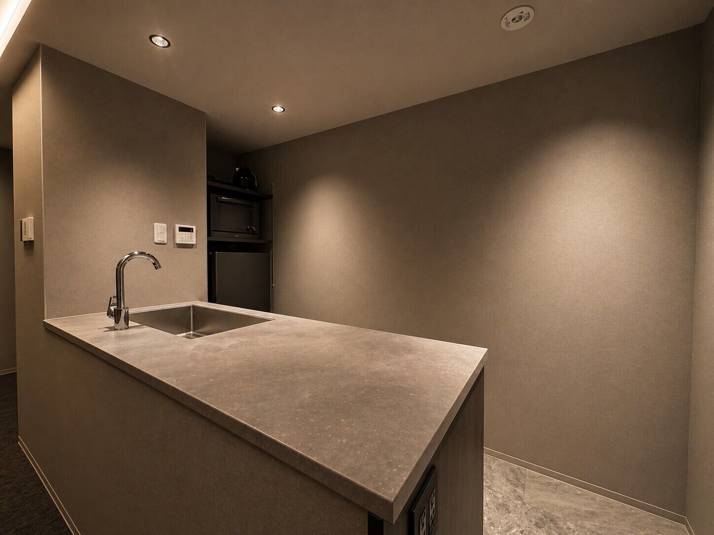 A modern kitchen with a built-in sink, a microwave, and a refrigerator.