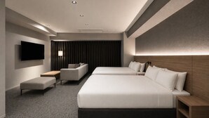 Ein modernes Hotelzimmer mit einem großen Bett, einer Sitzecke, einem Fernseher und einem Schreibtisch.