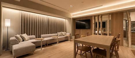 A modern living room with a sofa, a dining table, and chairs.