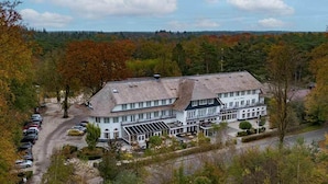 A large building with a central courtyard, surrounded by trees and a parking area. - Peaceful Forest Retreat with Bike Rentals, Breakfast, Terrace, and Free Parking (Vierhouten)