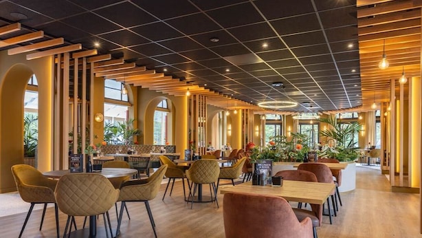 A modern interior with wooden flooring, round tables, and cushioned chairs. - Peaceful Forest Retreat with Bike Rentals, Breakfast, Terrace, and Free Parking (Vierhouten)
