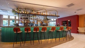 A bar area with a curved counter, multiple stools, and a variety of bottles and glasses. - Peaceful Forest Retreat with Bike Rentals, Breakfast, Terrace, and Free Parking (Vierhouten)