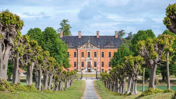 A large building with a symmetrical facade, a central entrance, and a pathway lined with trees. - Vacation at the Baltic Sea, freshly renovated, quiet vacation apartment, 3.5 km to the beach (OT Niederklütz)