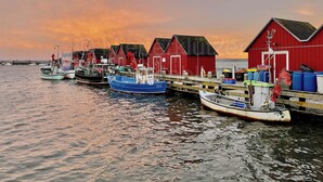 A harbor with boats docked, red wooden buildings, and calm water. - Vacation at the Baltic Sea, freshly renovated, quiet vacation apartment, 3.5 km to the beach (OT Niederklütz)
