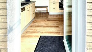 A kitchen with wooden cabinets, a bench, and a dining area with a table and chairs. - Vacation at the Baltic Sea, freshly renovated, quiet vacation apartment, 3.5 km to the beach (OT Niederklütz)