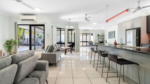 Eine moderne Küche mit Bar, einem Esstisch und einer Sitzecke mit Sofas.