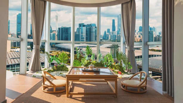 A modern room with a glass table, two chairs, and a city view. - Ritz Star City View Residence  (Guangzhou)