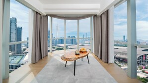 A modern room with a large window, a wooden table, and a view of a cityscape. - Ritz Star City View Residence  (Guangzhou)