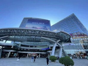 A modern building with a curved glass entrance and multiple floors. - Ritz Star City View Residence  (Guangzhou)