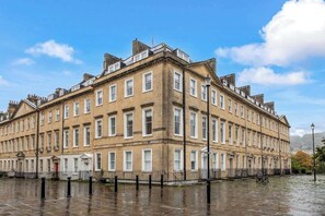 A multi-story building with a symmetrical facade, evenly spaced windows, and a corner entrance. - Bright & Spacious 1BR in Bath’s Centre - VAT Q (Bath)