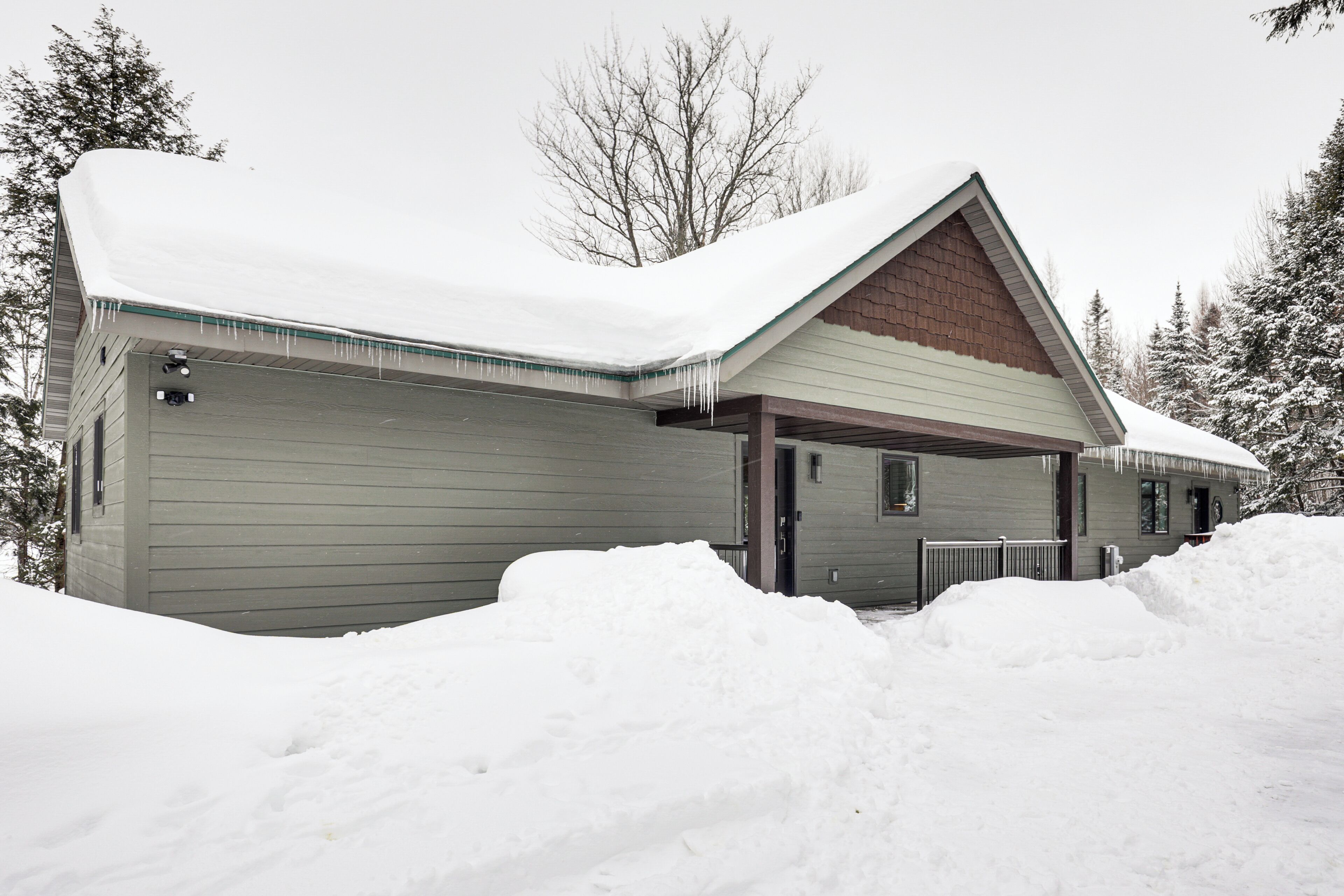A house with a snow-covered roof and a garage.