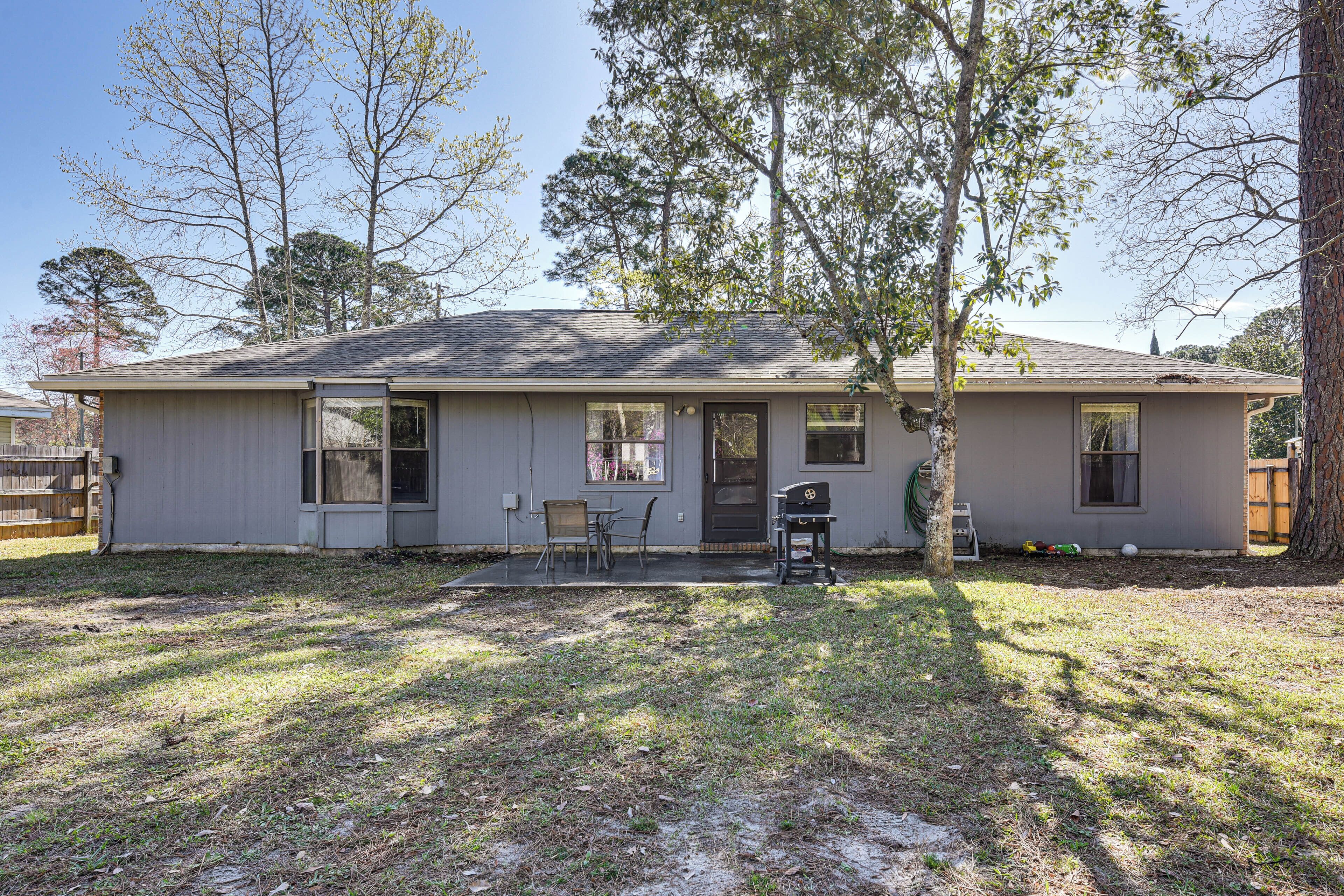A single-story house with a front porch, a small attached garage, and a lawn.