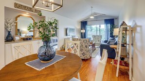 Ein Wohnzimmer mit Esstisch, Stühlen, einer Couch und einem Fernseher.