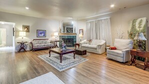 A living room with a fireplace, a sofa, a coffee table, and a lamp.