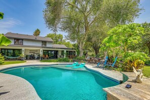 A residential property with a swimming pool, outdoor seating, and lush greenery. - Group Getaway: Luxe Riverfront Gem in Los Fresnos! (Los Fresnos)