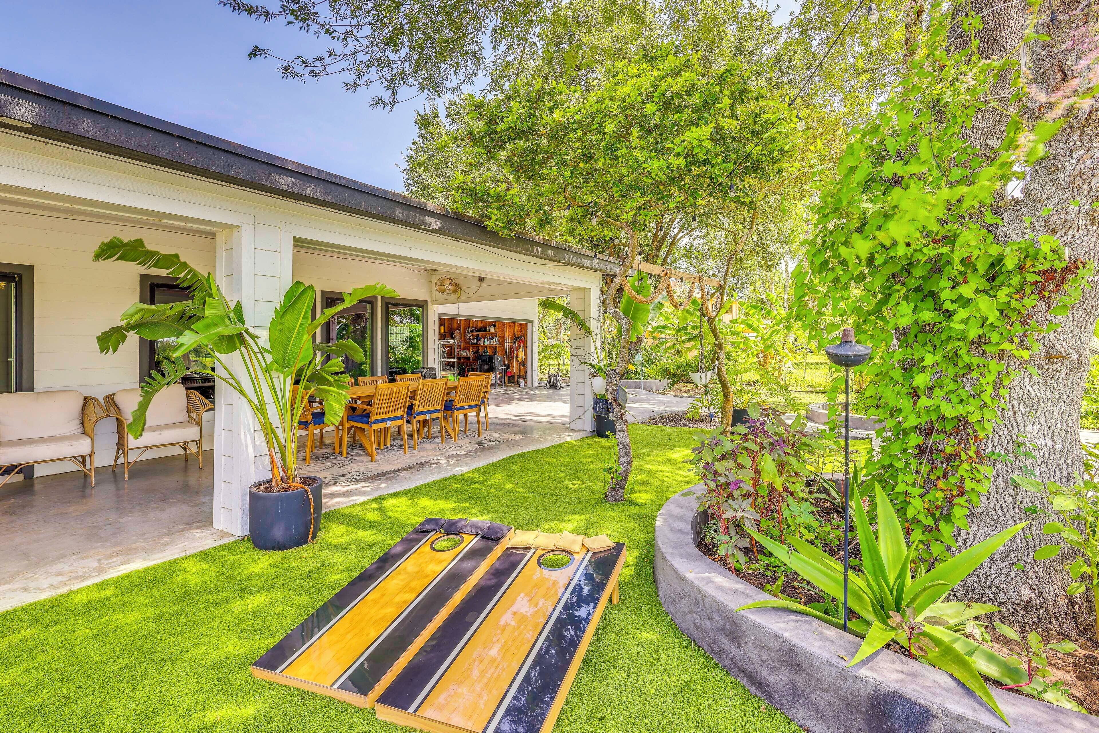 A well-maintained outdoor area with a dining table and chairs, surrounded by lush greenery and a variety of plants.