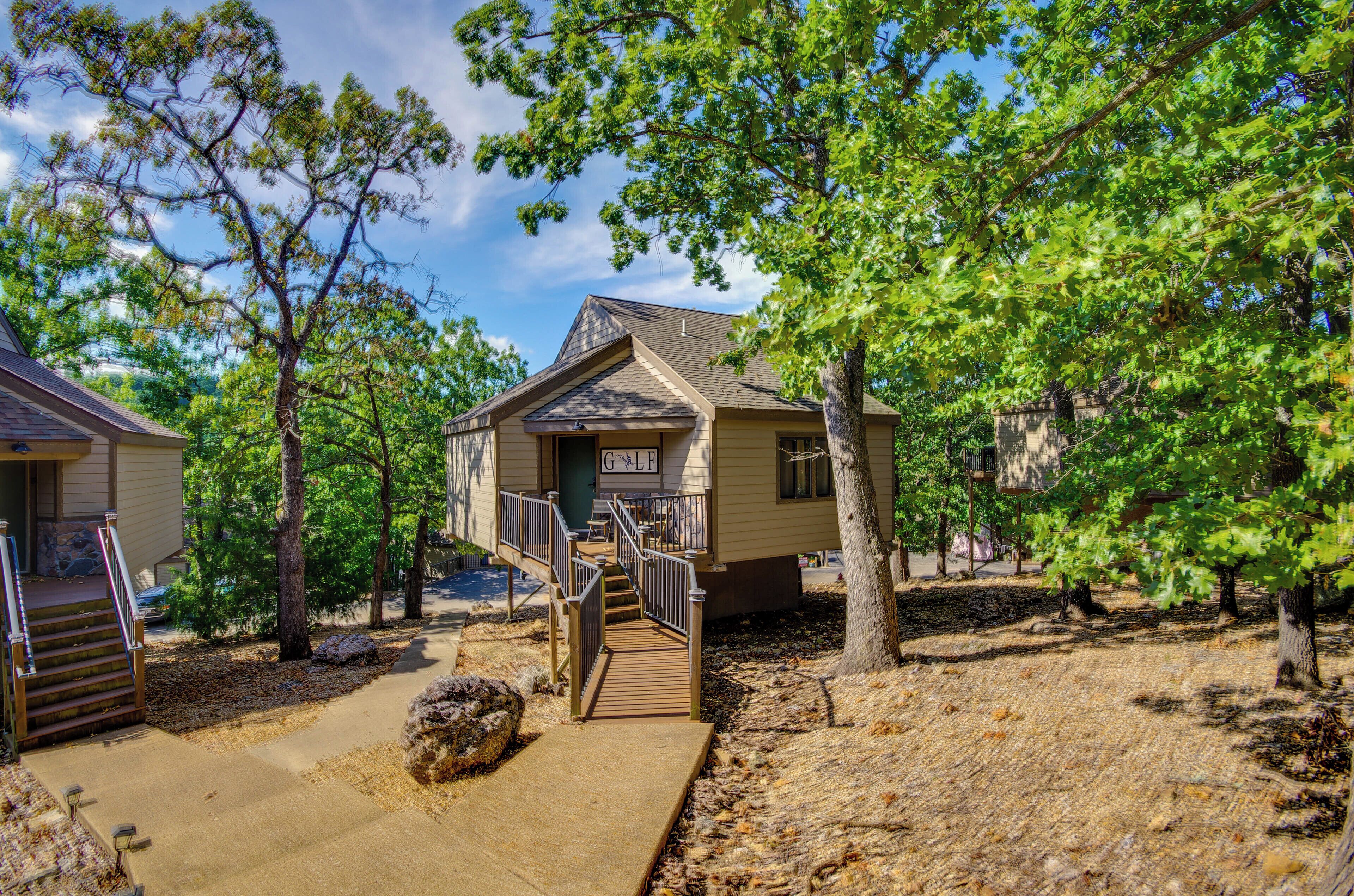A small building with a porch and a staircase leading to a deck.