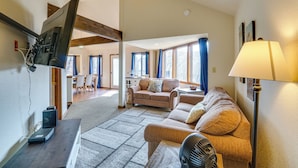 A living room with a sofa, a TV mounted on the wall, a lamp, and a fan. - Pet-friendly Lakefront Escape in Osage Beach (Osage Beach)