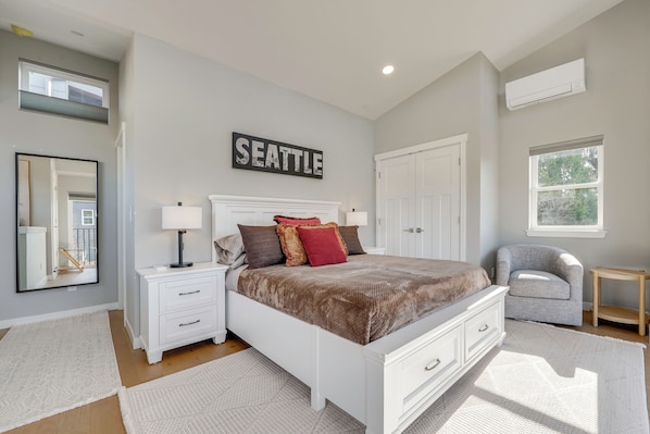 Une chambre à coucher comprenant un lit, des tables de chevet, une chaise, un miroir, une cheminée et un panneau décoratif fixé au mur.