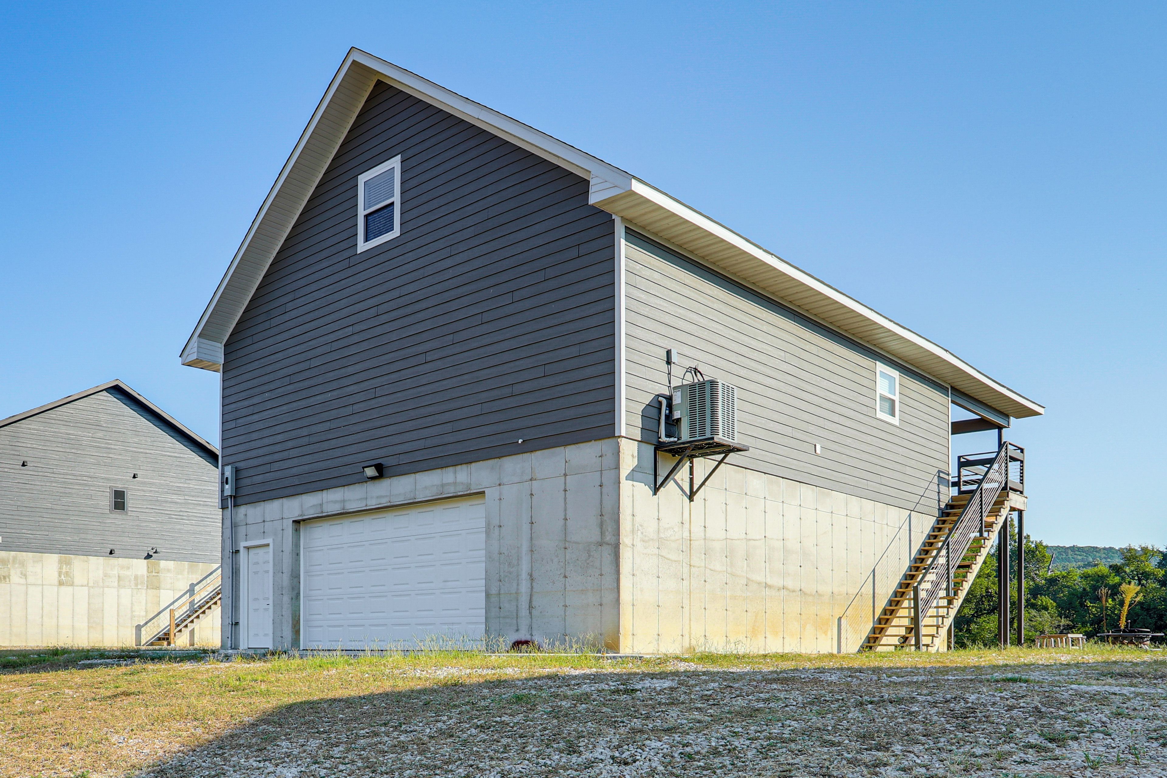 A single-story building with a garage, a small window, and a staircase leading to a second level.
