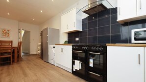 A modern kitchen with a built-in oven, a microwave, and a washing machine.