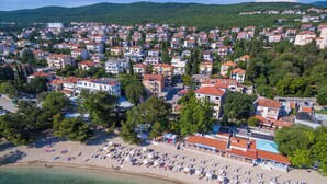 A coastal town with a beach, numerous buildings, and a hilly backdrop. - Beautiful apartment near the beach with pool (Crikvenica)