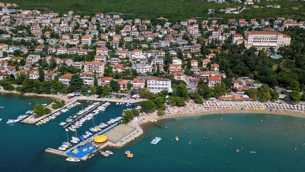 An aerial view of a coastal town with a marina, beach, and residential buildings. - Beautiful apartment near the beach with pool (Crikvenica)
