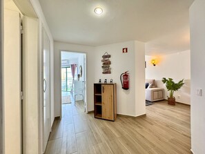 A hallway with a wooden cabinet, a fire extinguisher, and a wall with motivational signs. - VILAMOURA CENTRAL BEACH  1  WITH POOL by HOMING (Vilamoura)