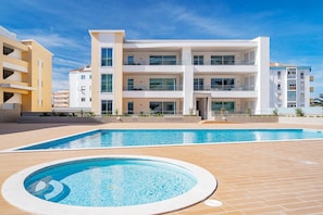 Ein modernes Mehrstöckhotel mit Schwimmbad und Whirlpool.