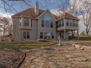 A two-story house with a stone pathway leading to the entrance. - Chateau du Golf by Innsbrook Vacations! (Innsbrook)
