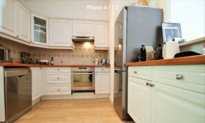 A kitchen with white cabinets, a dishwasher, an oven, and a refrigerator. - Golf Juan - Vallauris / Exceptional south-facing sea view (Vallauris)