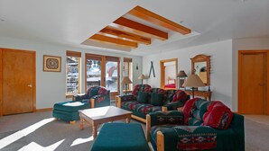 A spacious living room with a high ceiling, large windows, and a view of the outside. - 4208 - One Bedroom Standard Creekside Condominiums 1 Condo (Solitude)