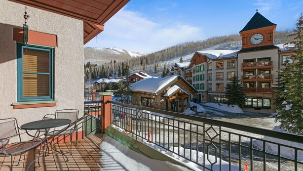 A hotel with a balcony, outdoor seating, and a view of a snowy mountain town. - 4208 - One Bedroom Standard Creekside Condominiums 1 Condo (Solitude)