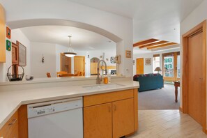 Una cocina moderna con lavavajillas, armarios de madera y un espejo grande.