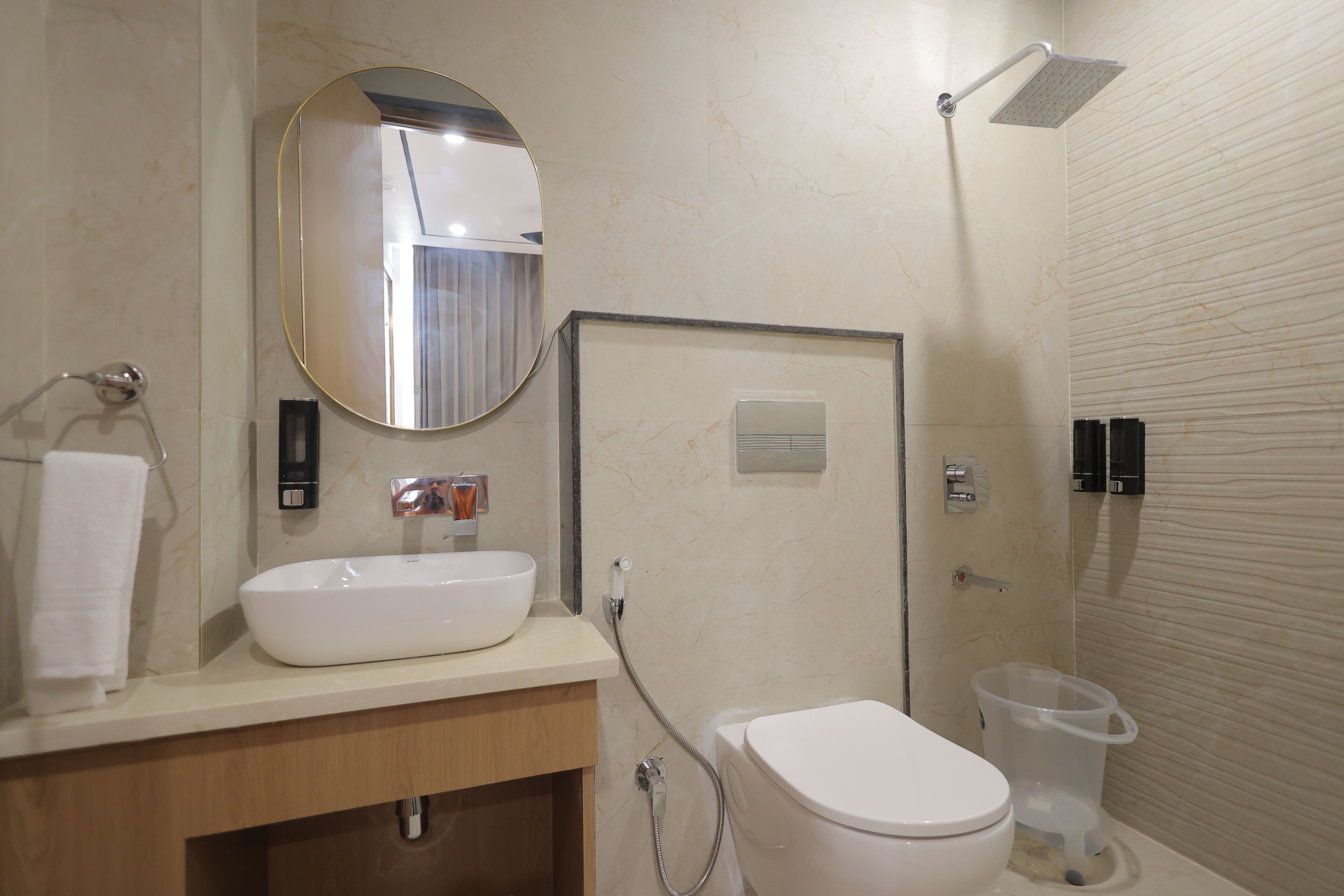 A bathroom with a white sink, a mirror, a toilet, and a shower.