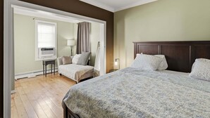 A room with two beds, a window with blinds, a lamp, and a small table. - Cozy Pleasantville Retreat Unit 2 2 Bedroom Apts (Pleasantville)