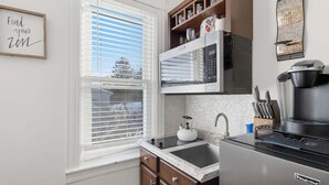 A kitchen with a microwave, kettle, coffee maker, and cabinets. - Cozy Pleasantville Retreat Unit 2 2 Bedroom Apts (Pleasantville)