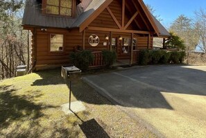 A wooden lodge with a porch, a mailbox, and a clear sky. - Airport Runway 33 3 Bedroom Cabin (Pigeon Forge)