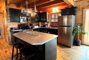 A kitchen with wooden walls, a stainless steel refrigerator, a microwave, and a coffee station. - Airport Runway 33 3 Bedroom Cabin (Pigeon Forge)