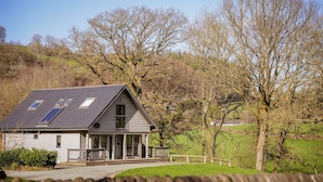 A house with a sloped roof, skylights, and a porch. - Oak Lodge (Knighton)