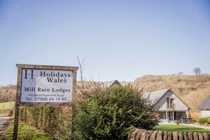 A sign for Holidays Wales Mill Race Lodges with contact information. - Oak Lodge (Knighton)