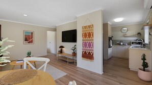 Un appartamento moderno con soggiorno, zona pranzo e cucina.