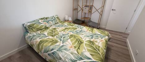 Une chambre à coucher avec un lit, une armoire en bois et une table de chevet avec une lampe.