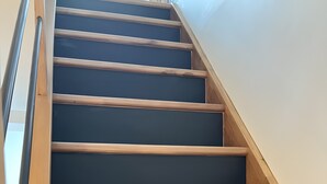 A wooden staircase with dark steps and a wooden handrail. - Holiday Home “Gîte Le Pré Salé” with Private Terrace and Wi-Fi (Boismont)