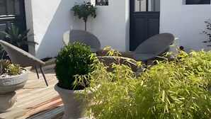 A patio with two chairs, a potted plant, and a small table. - Holiday Home “Gîte Le Pré Salé” with Private Terrace and Wi-Fi (Boismont)