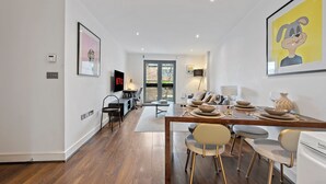 Un espace repas moderne avec une table en bois, des chaises et une cuisine en arrière-plan.