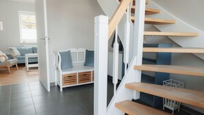 Un intérieur moderne avec un escalier, un canapé et un banc.