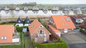 Un quartier résidentiel avec des maisons, un étang et un ciel dégagé.