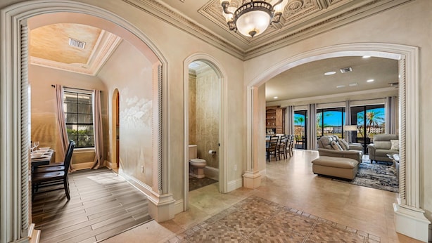 A spacious living area with a fireplace, a dining area with a table and chairs, and a view of the outdoors. - 7811 Palmilla Court (Kissimmee)