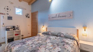 Un dormitorio con una colcha de flores, un reloj de pared, una cafetera y un cartel que dice 'sweet dreams'.